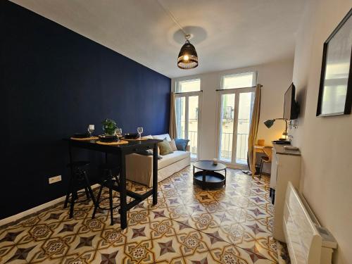 un salon avec une table et un canapé dans l'établissement Évasion bleue, balcon ensoleillé, à Nîmes