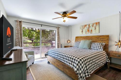 a bedroom with a bed with a ceiling fan and a window at Arrowhead Falls in Wimberley