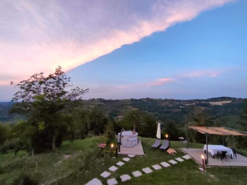 a group of tables and umbrellas on top of a field at Dimora DarSenso in Albaretto Della Torre 