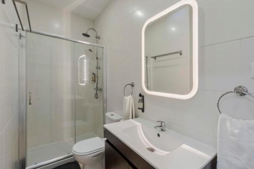 a white bathroom with a sink and a shower at City Life in Setubal