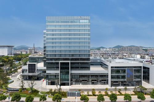 a tall glass building with a city in the background at Four Points by Sheraton Xuancheng, Jingxian in Jingxian