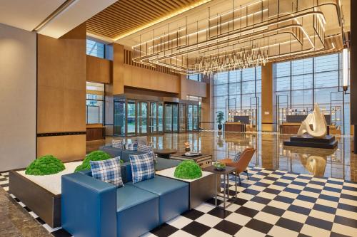 a lobby with a blue couch and a checkered floor at Four Points by Sheraton Xuancheng, Jingxian in Jingxian