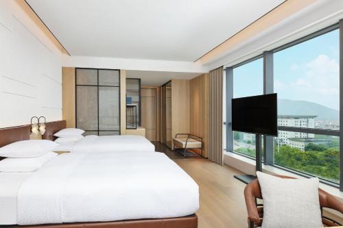 a bedroom with two beds and a flat screen tv at Four Points by Sheraton Xuancheng, Jingxian in Jingxian