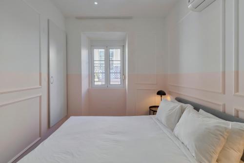 a bedroom with a large white bed with a window at City Life in Setubal