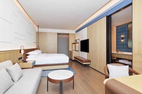 a hotel room with two beds and a couch at Four Points by Sheraton Xuancheng, Jingxian in Jingxian