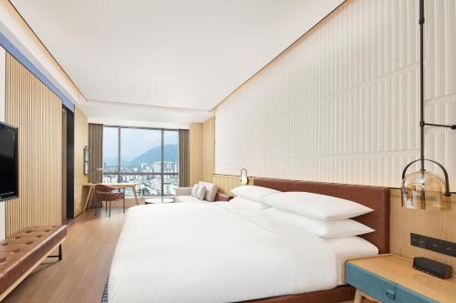 a bedroom with a large bed with white pillows at Four Points by Sheraton Xuancheng, Jingxian in Jingxian