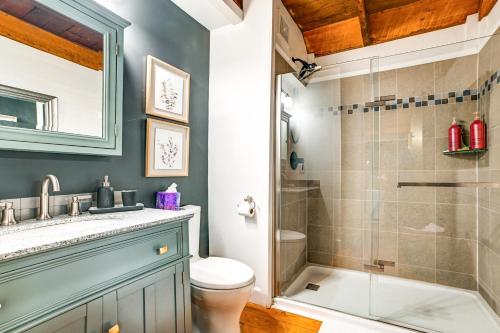 a bathroom with a toilet sink and a shower at Lovely Gilbertsville Cabin with Patio, 4 Mi to Water in Gilbertsville