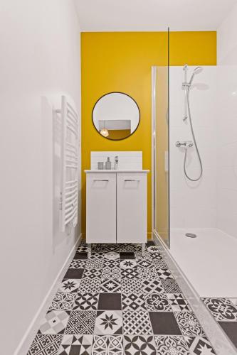 une salle de bain avec un lavabo et une douche dans l'établissement Les Suites de l'Arc-en-Ciel, à Bourg-en-Bresse