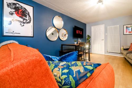 a living room with a couch and mirrors on the wall at 2-Bed House with Garden & Free Parking, Quiet Location, Cwmbran in Cwm-brân