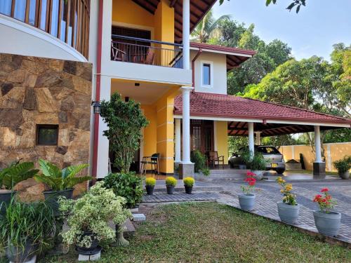 a house with a courtyard and flowers in pots at Bigcity Villa - Airport Transit Hotel in Katunayake