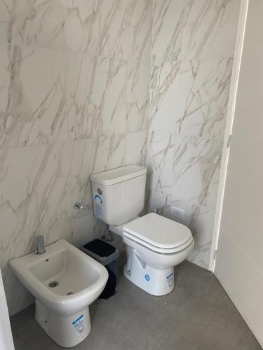 Un baño con un inodoro blanco y un lavabo. en J-M-L DEPARTAMENTO 5a, en Monte Hermoso