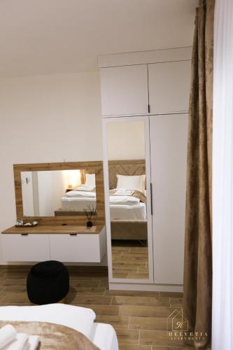 a bedroom with a mirror and two beds at Helvetia Apartments in Jajce