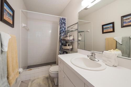 a bathroom with a sink and a toilet and a mirror at Seabreeze D in Holmes Beach