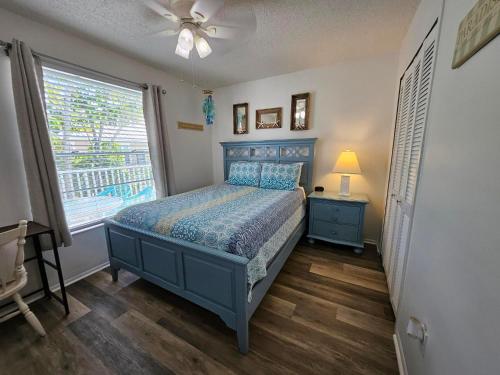 a bedroom with a blue bed and a window at Seabreeze D in Holmes Beach