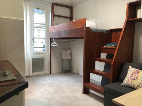 Cette petite chambre comprend des lits superposés et un canapé. dans l'établissement Le studio de Bastille Paris, à Paris