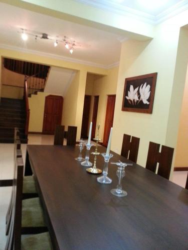 a dining room with a long table with candles on it at Bigcity Villa - Airport Transit Hotel in Katunayake