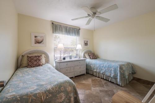 a bedroom with two beds and a ceiling fan at Seabreeze A in Holmes Beach