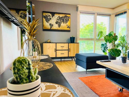 un salon avec des plantes en pot et une table dans l'établissement Cosy & Lumineux - Balcons - Spacieux - Parking rue, à Orléans