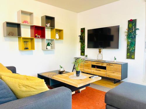 un salon avec un canapé et une télévision dans l'établissement Cosy & Lumineux - Balcons - Spacieux - Parking rue, à Orléans