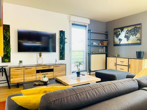 un salon avec un canapé et une télévision à écran plat dans l'établissement Cosy & Lumineux - Balcons - Spacieux - Parking rue, à Orléans