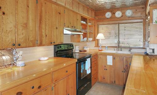 a kitchen with wooden cabinets and a stove top oven at Deja View Cabin in Wimberley