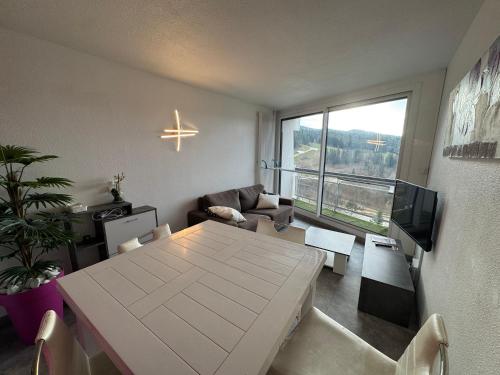 un salon avec une table et une grande fenêtre dans l'établissement Les Balcons de Villards - Au pied des Pistes, à Villard-de-Lans