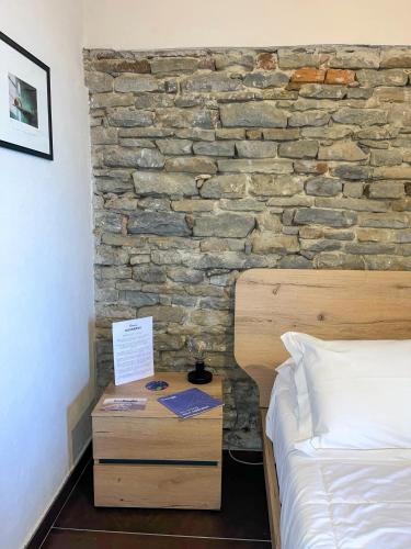 a bedroom with a bed and a stone wall at Dimora DarSenso in Albaretto Della Torre 