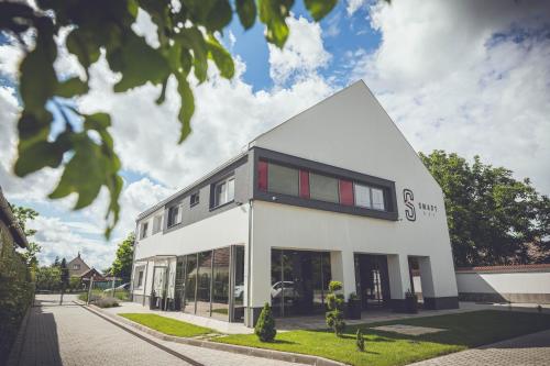 a white building with red windows at Smart HTL in Körösladány