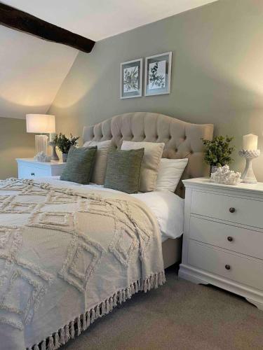 a bedroom with a large bed and a white dresser at Penddol Cottage & Boathouse in Llangollen
