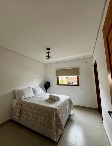 a bedroom with a bed and a window at Serra Vale D l 2 Suítes l Centro Histórico l Garagem in Tiradentes