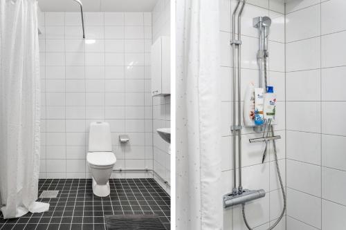 a bathroom with a shower with a toilet and a sink at Guestly Homes - Elite Studio Apartment in Nyköping