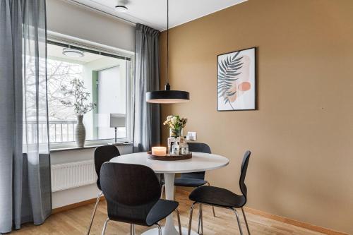 a dining room with a table and chairs and a window at Guestly Homes - Elite Studio Apartment in Nyköping