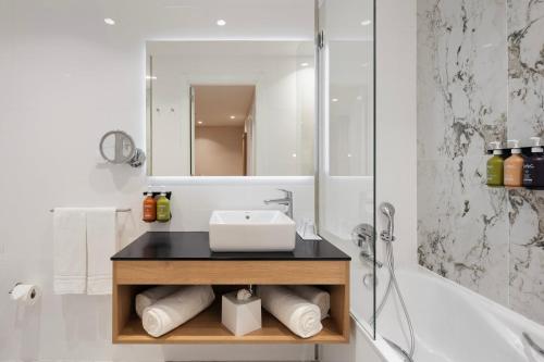 a bathroom with a sink and a bath tub at Holiday Inn Braga by IHG in Braga