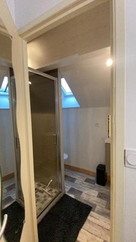 un couloir avec une douche en verre dans une maison dans l'établissement L'annexe, à Savoisy