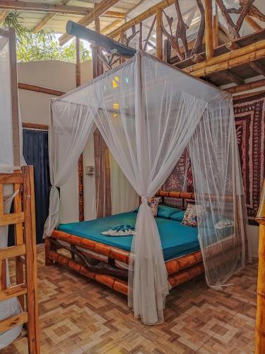 a bed with mosquito netting in a room at Kanta Sana in Palomino