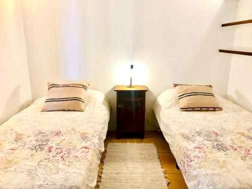 - 2 lits jumeaux dans une chambre avec une table de nuit dans l'établissement Villa Es Repaire near to Playa Den Bossa, à Ibiza