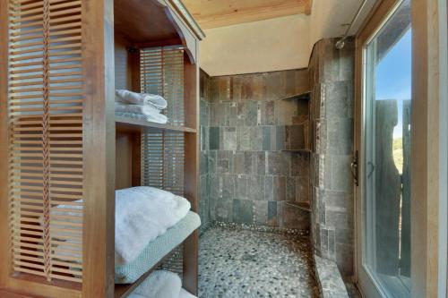 Un baño con ducha con puerta de cristal. en Casa Artista, en Payton