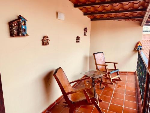 two chairs and a glass table in a room at La Casita de Elenita in Chiriquí
