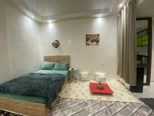 a bedroom with a bed and a table in it at la poste in Imouzzer Kandar