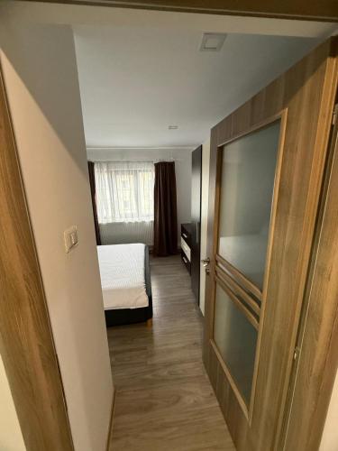 a small room with a bed and a window at La Maria in Comăneşti