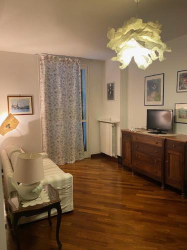 a living room with a couch and a tv and a lamp at Nonna Gabri in Cantù
