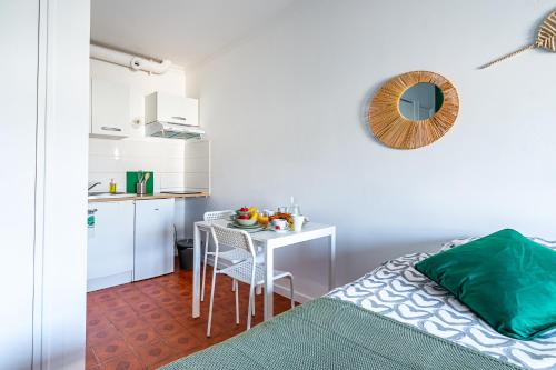 - une chambre avec une table et une petite cuisine dans l'établissement Charmant studio avec terrasse, Gare à 200m et parking gratuit, à Saint-Cyr-lʼÉcole