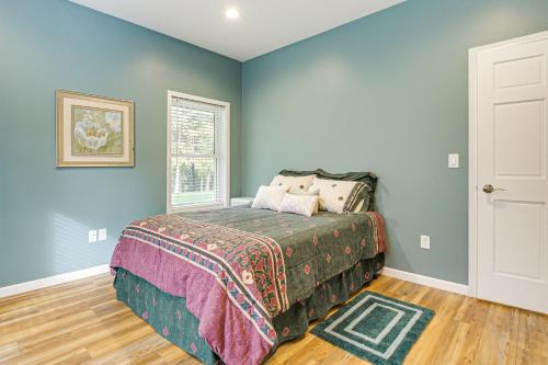 Un dormitorio con una cama con paredes azules y una ventana. en 2 Mi to Lake Michigan Home with Patio in Green Bay, en Green Bay