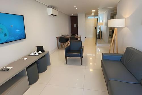 a living room with a couch and a tv on a wall at Apartamento Super Luxo com vista in João Pessoa