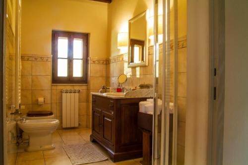 baño con lavabo y aseo y ventana en L'Orangerie, en Cortona