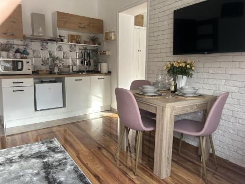 a kitchen with a wooden table with purple chairs at Alma Mons in Vrdnik