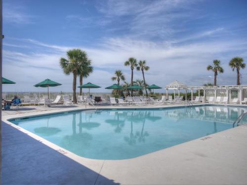 a large swimming pool with chairs and umbrellas at 103 Seacrest in Hilton Head Island