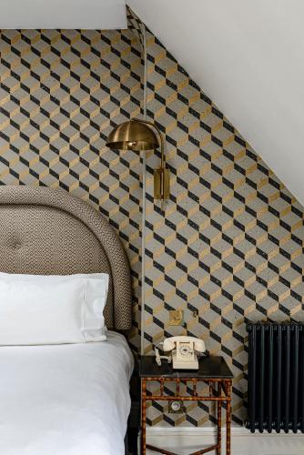 a bedroom with a bed and a table with a phone at Grand Pigalle Experimental in Paris