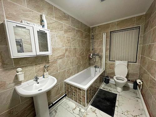 a bathroom with a sink and a toilet and a tub at Modern Flat near StarCity, Bull Ring & M6 in Birmingham