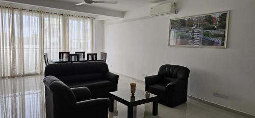 a living room with two chairs and a table at Rodrigo Building 4 in Boralesgamuwa